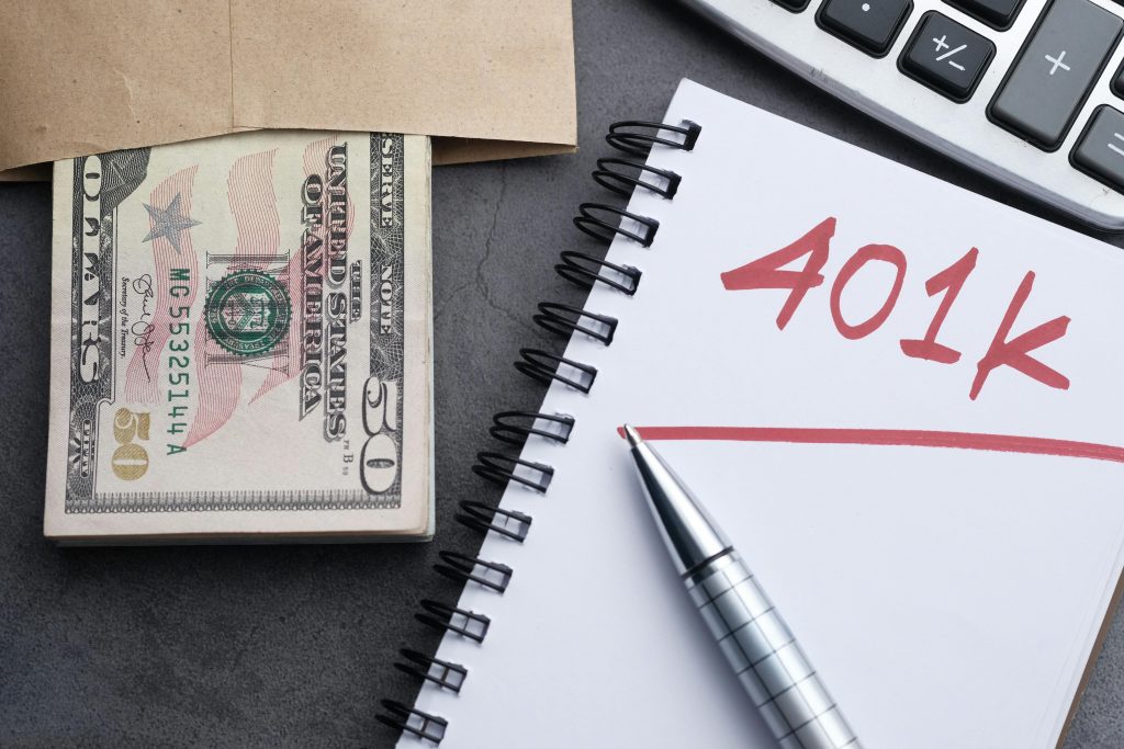 notebook with "401k" next to an envelope of cash